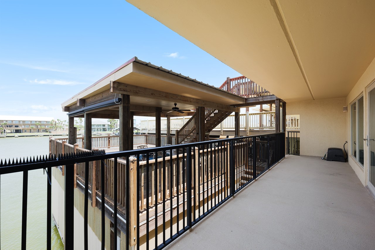 the deck facing the harbor is shared with the condo upstairs the stairway in the background is the access to the deck from the condo above this one. from this condo, the access is the same level as their deck