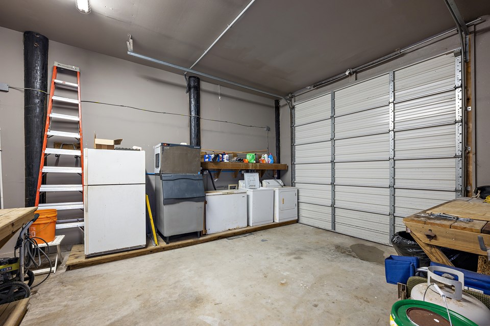enclosed garage with washer, dryer, freezer and ice maker