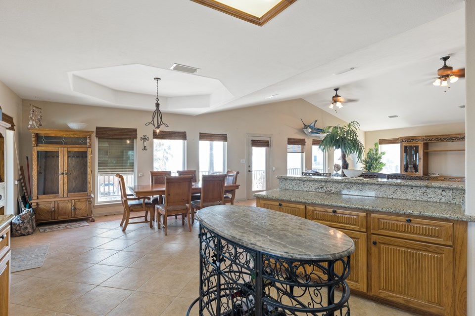 open kitchen, living, and dining area. the main door to the upstairs is located at your left (now shown in the picture).  there is also a main door in the background center which leads to the covered deck overlooking the bay.