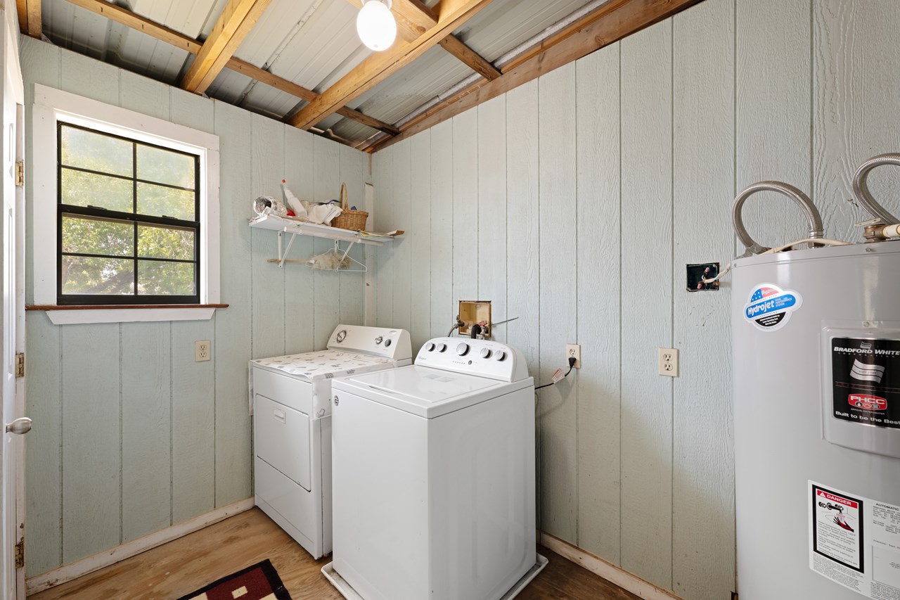 laundry room with water heater and storage closet