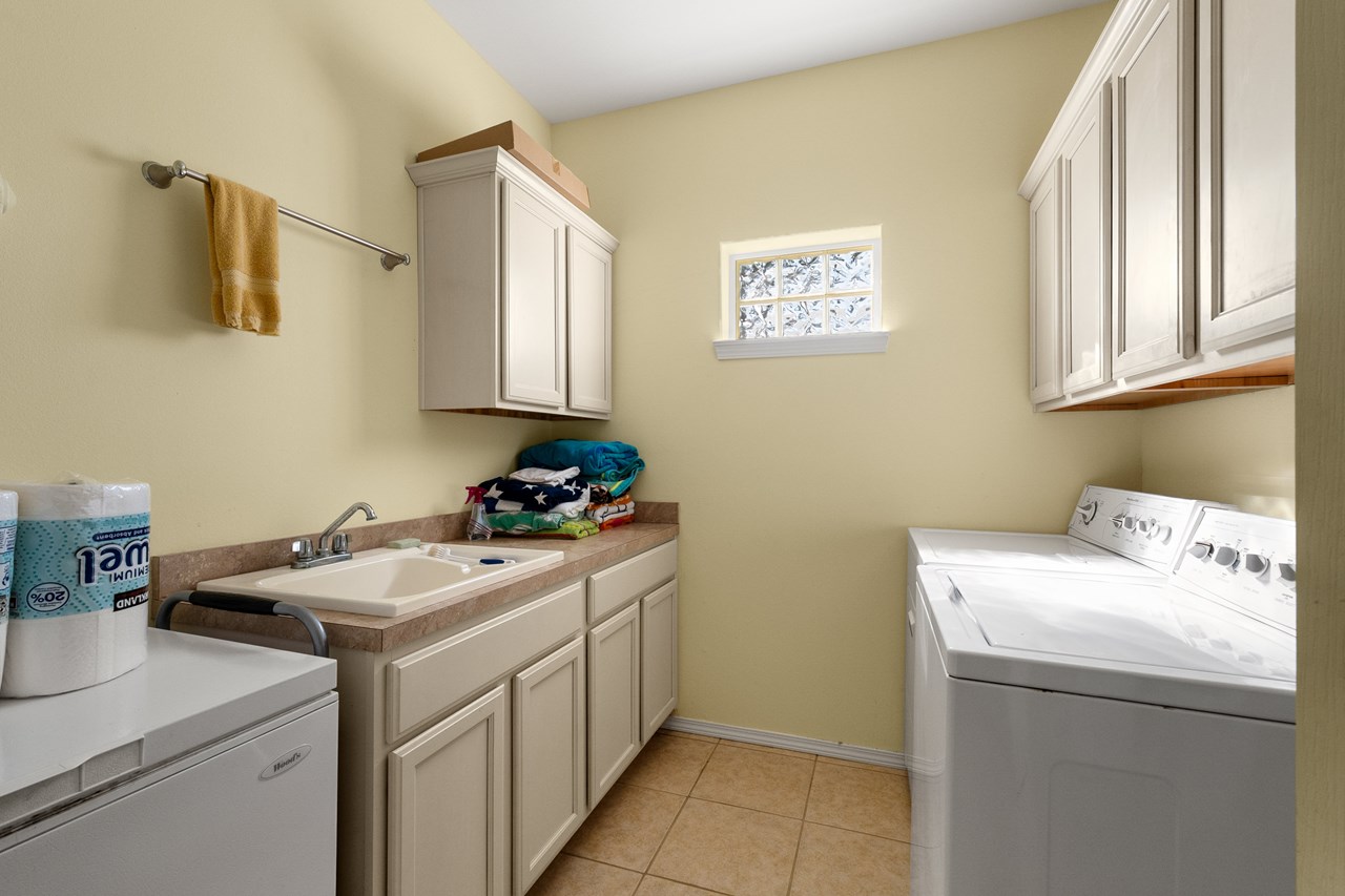 separate laundry room with sink and additional storage